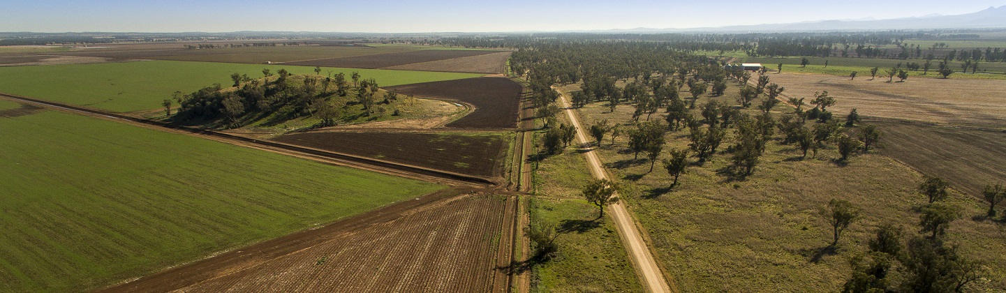 Agricultural land with tilled soil, pasture and some native trees
