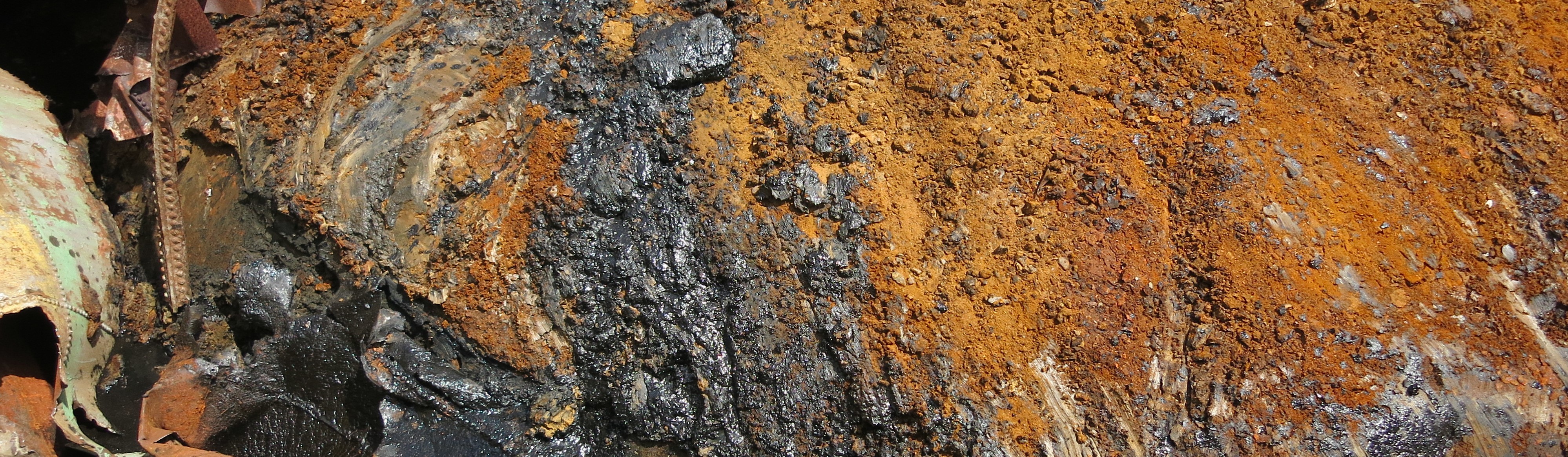 Close up of Gasworks Remediation Site showing rust gear and oil