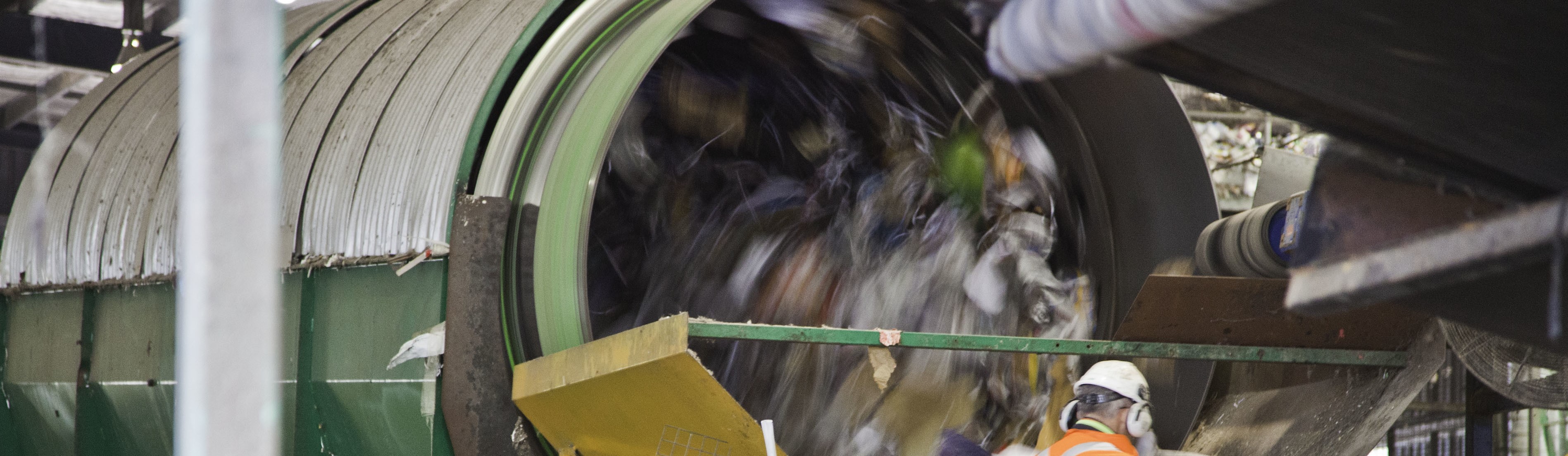 Man standing in front of sorting machine at a Materials Recycling Facility